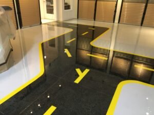black and yellow road design epoxy floor for a motorcycle showroom near Ottawa, Ontario