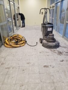 Surface preparation with concrete grinding equipment at Home Hardware store entrance in Ontario before installing MMA industrial high-traffic flooring